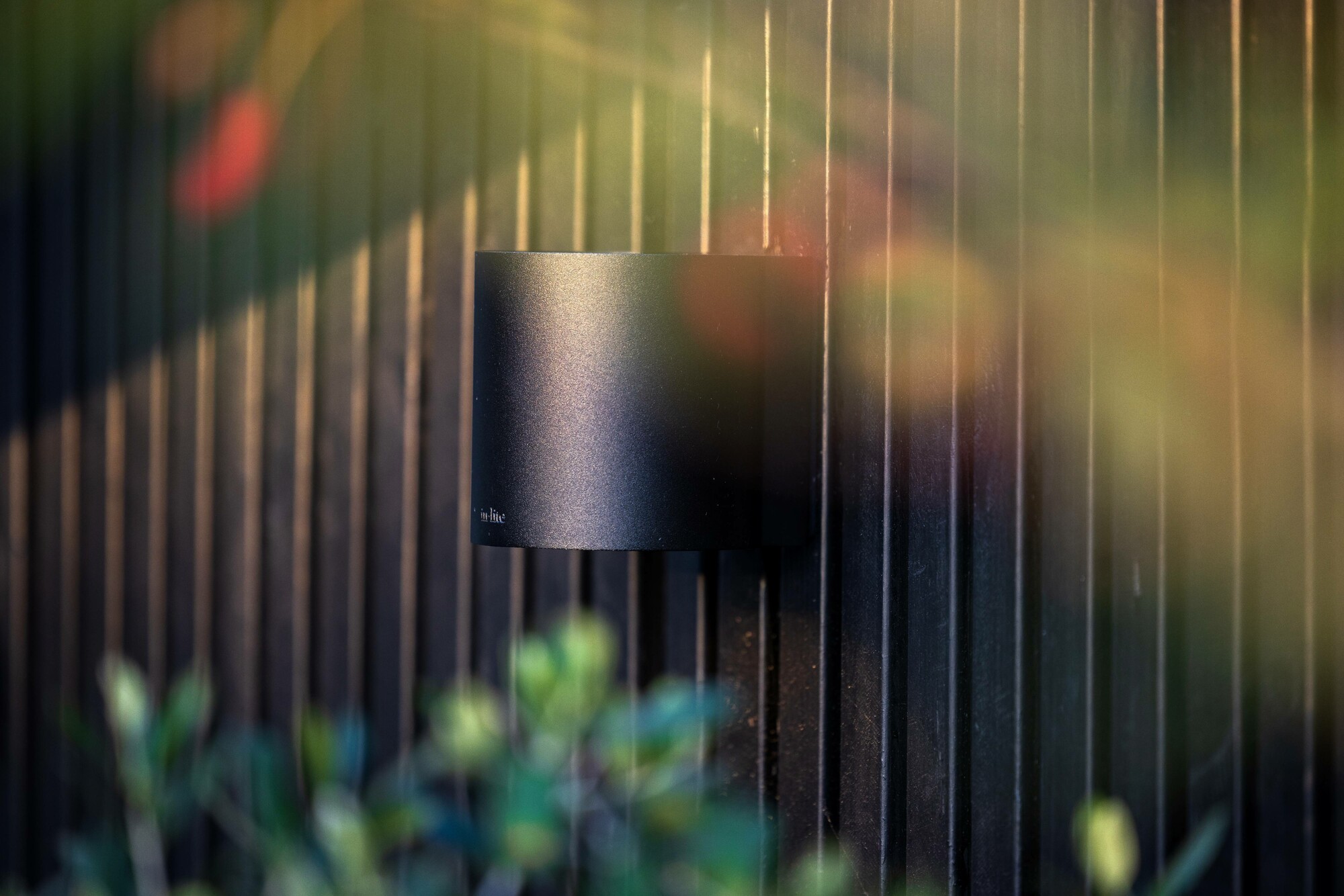 Eine runde LED-Außenwandleuchte mit Up-and-Down-Effekt, die an einer Wand befestigt ist.